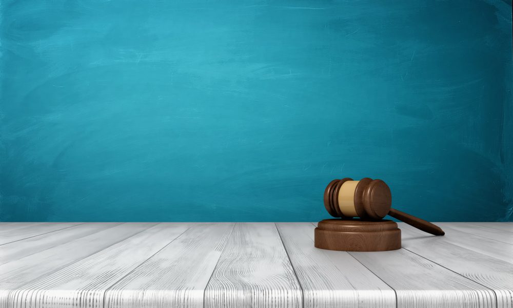 3d rendering of a brown wooden judge gavel and sound block lying on a  wooden table against blue background - Boyle | Shaughnessy Law
